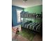 bedroom with bunk beds, blue and green accent walls, window and colorful area rug at 2208 Ginger Lake Ne Dr, Conyers, GA 30013