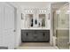 Bathroom featuring double sink vanity, tile floors, decorative mirrors, and glass shower door at 4065 Holland Grove, Lawrenceville, GA 30044
