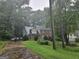 Traditional two-story home with a mix of brick and siding, surrounded by mature trees and a well-manicured lawn at 423 Orchards Walk, Stone Mountain, GA 30087