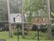 Stylish two-story home with a brick facade, surrounded by lush greenery and enclosed by a decorative iron fence at 423 Orchards Walk, Stone Mountain, GA 30087