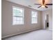Bright bedroom featuring neutral walls, plush carpeting, two windows, and ceiling fan for comfort at 1555 New Ne St, Atlanta, GA 30307
