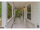 Inviting front porch with white columns, railing and beadboard ceiling offers views of mature trees at 1555 New Ne St, Atlanta, GA 30307