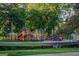 Colorful community playground with slides, swings, and climbing structures nestled among mature trees at 1555 New Ne St, Atlanta, GA 30307