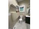 Charming bathroom featuring tiled floors, floating shelves and a green vanity cabinet with sink at 2148 M L King Jr Sw Dr, Atlanta, GA 30310