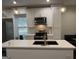 Stylish kitchen with a central island, stainless steel appliances, white cabinets, and attractive pendant lights at 2148 M L King Jr Sw Dr, Atlanta, GA 30310