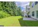 Expansive backyard with lush green grass, mature trees, and concrete patio at 513 Shadow Valley Ct, Lithonia, GA 30058
