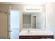 Bright bathroom featuring a large mirror, cherry vanity, and combination tub and shower at 513 Shadow Valley Ct, Lithonia, GA 30058