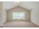 Spacious bedroom featuring a vaulted ceiling, neutral walls, plush carpet, and a large window at 513 Shadow Valley Ct, Lithonia, GA 30058