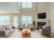Bright living room with a fireplace, large windows and plush white rug offers a cozy space for relaxation at 513 Shadow Valley Ct, Lithonia, GA 30058