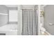 Bright bathroom with a tub, shower with black and white curtain, gray walls and wood-look floor at 950 Besse Way, Locust Grove, GA 30248