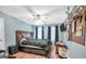 This bedroom features a wood frame bed, light-wood look floors, blue walls and bright windows at 950 Besse Way, Locust Grove, GA 30248
