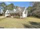 Low angle view of a charming house with white siding, large windows, and lush green lawn at 950 Besse Way, Locust Grove, GA 30248