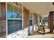 Cozy front porch featuring rocking chairs, windows with shutters, and painted brick at 950 Besse Way, Locust Grove, GA 30248