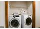Efficient laundry room with side-by-side, full-size Samsung washer and dryer and wire shelving for storage at 1587 Cronic Town Rd, Auburn, GA 30011