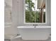 Bright bathroom featuring soaking tub and walk-in shower with forest views at 3893 Indian Shoals Road, Dacula, GA 30019