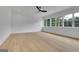 Bright bedroom with hardwood floors, modern ceiling fan, and accent wall with large windows at 3893 Indian Shoals Road, Dacula, GA 30019