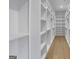 Walk-in closet with built-in shelving and hardwood floors at 3893 Indian Shoals Road, Dacula, GA 30019