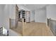 Open hallway with wood floors, and view of an office with french doors and built-in shelving at 3893 Indian Shoals Road, Dacula, GA 30019