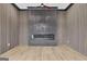 Living area with wood floors, linear fireplace with stone surround, and slat wood accent walls at 3893 Indian Shoals Road, Dacula, GA 30019
