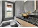 Stylish powder room features marble counters, a gold sink, and designer finishes at 3893 Indian Shoals Road, Dacula, GA 30019