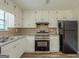 Modern kitchen with stainless steel appliances, granite counters, and white cabinetry at 5207 Shawn Ln, Stone Mountain, GA 30088