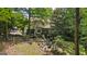 Expansive backyard featuring a cozy fire pit area, a lush lawn, and a serene pond, ideal for outdoor living and entertaining at 1788 River Bluff Vw, Duluth, GA 30097