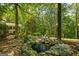 Picturesque backyard oasis featuring a serene pond surrounded by lush greenery and a charming patio area at 1788 River Bluff Vw, Duluth, GA 30097