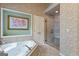 Bright bathroom with soaking tub and shower, featuring elegant wallpaper and tile flooring at 1788 River Bluff Vw, Duluth, GA 30097
