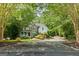Charming home with a stone and siding exterior, covered porch, and a circular driveway surrounded by mature trees at 1788 River Bluff Vw, Duluth, GA 30097