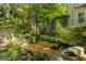 Tranquil backyard pond teeming with colorful koi fish, complemented by lush landscaping and a relaxing deck area at 1788 River Bluff Vw, Duluth, GA 30097