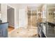 Bathroom featuring double vanities, shower with diamond accent tile and stone floors at 1884 Whitehawk Ct, Lawrenceville, GA 30043