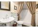 Bathroom featuring a pedestal sink, decorative mirror, and tiled shower-tub combination with patterned curtain at 1884 Whitehawk Ct, Lawrenceville, GA 30043
