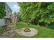 Spacious backyard features a stone patio with a fire pit and lush greenery at 3355 Golfe Links Dr, Snellville, GA 30039