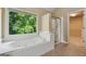 Relaxing main bathroom with soaking tub, walk-in shower, and serene outdoor view at 3355 Golfe Links Dr, Snellville, GA 30039