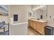Bright bathroom featuring double sinks with a wooden cabinet, a large mirror and earth-tone flooring at 2083 Hasel St, Lawrenceville, GA 30044