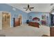 Spacious bedroom featuring blue walls, vaulted ceilings, ceiling fan, and matching wood furniture at 2083 Hasel St, Lawrenceville, GA 30044
