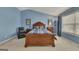 Comfortable primary bedroom featuring light blue walls, carpet, and a wooden bed frame and headboard at 2083 Hasel St, Lawrenceville, GA 30044