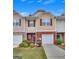 Well-kept townhome boasts a one-car garage, brick facade, and professionally landscaped front yard at 2083 Hasel St, Lawrenceville, GA 30044