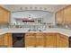 Open kitchen featuring tile backsplash, light wood cabinets and stainless steel dual basin sink at 2083 Hasel St, Lawrenceville, GA 30044