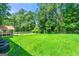 Expansive backyard with lush green grass, mature trees, and a charming covered patio, perfect for outdoor living at 2117 Chestnut Hill Circle Cir, Decatur, GA 30032