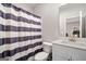 Bathroom featuring vanity with framed mirror and shower-tub combo with striped curtain at 234 Retreat Ln, Canton, GA 30114