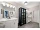 Modern bathroom with dual vanities, stylish mirror and lighting, with a black cabinet with glass doors at 234 Retreat Ln, Canton, GA 30114
