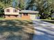 Split-level home with brick accents, red shutters, attached garage, and long driveway at 6332 Valley Dale Dr, Riverdale, GA 30274