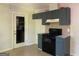 Kitchen with tile floor, dark blue cabinets, and black appliances with an adjacent door at 6332 Valley Dale Dr, Riverdale, GA 30274