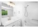 All-white bathroom with shower-tub combination and a window with a view to the backyard at 191 High Creek Dr, Roswell, GA 30076