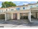 Charming townhome featuring a carport with bright red double doors, set under a partially shaded sky at 191 High Creek Dr, Roswell, GA 30076