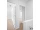 Hallway featuring neutral carpet, white walls, and doors leading to other rooms of the home at 191 High Creek Dr, Roswell, GA 30076