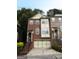 Well-maintained brick townhome showcasing a garage and well manicured front yard at 2084 Cobblestone Ne Cir, Brookhaven, GA 30319