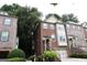 Three-story brick townhome with a garage and front steps, complemented by green landscaping at 2084 Cobblestone Ne Cir, Brookhaven, GA 30319