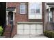 Close-up of a brick townhome featuring a garage and front entrance with steps at 2084 Cobblestone Ne Cir, Brookhaven, GA 30319